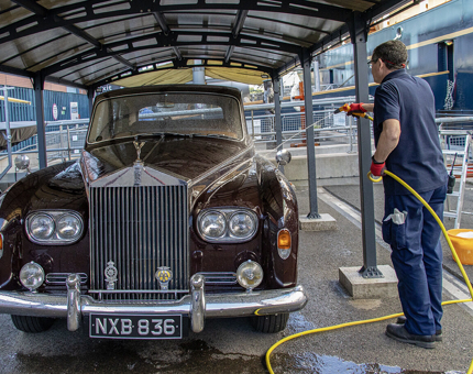 A member from the Facilities team hosing down the vintage Rolls-Royce car.