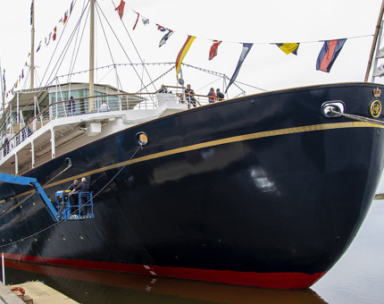 The Maintenance team paint Britannia's hull while on a cherry picker.