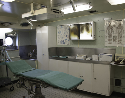 Operating Theatre interior with hospital bed and X-Ray machines mounted on the wall.