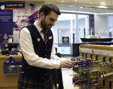 Man arranges novelty keyrings in the Britannia Gift Shop.